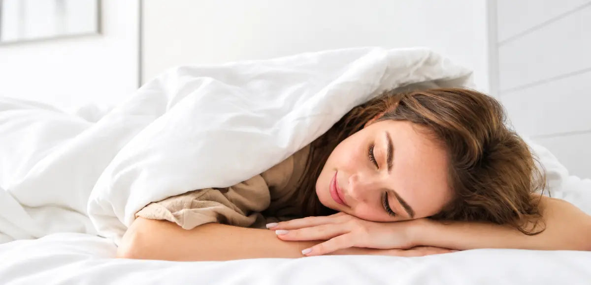 Woman sleeping on her stomach on a comfortable mattress, illustrating the ideal sleeping position for stomach sleepers.