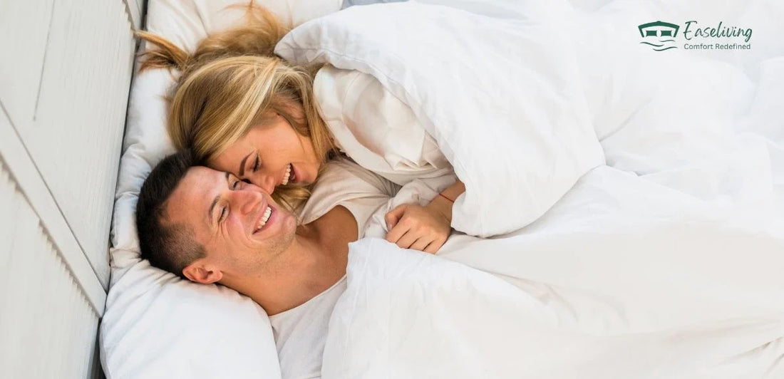 Couple smiling comfortably in bed on a motion-isolating mattress designed for uninterrupted sleep.
