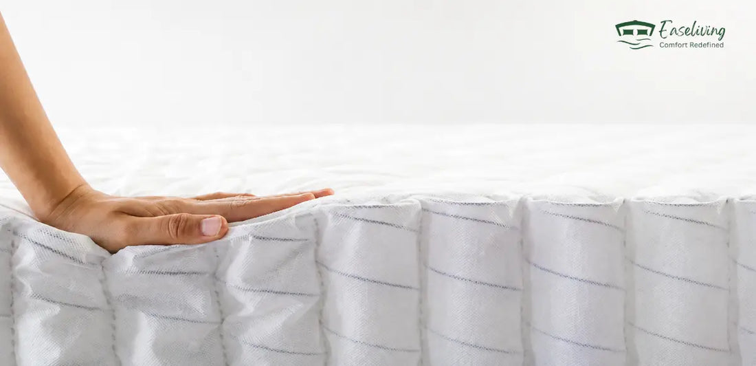 Hand pressing down on a pocket spring mattress, showing its individually wrapped springs and responsive support.